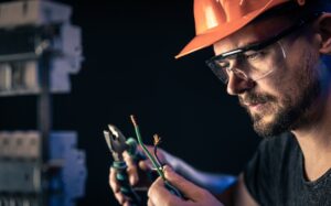 a-male-electrician-works-in-a-switchboard-with-an-electrical-connecting-cable-.jpg